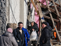 A woman carries a bag with belongings salvaged from a house destroyed by a large-scale Russian missile strike in the Odesa region, Ukraine,...