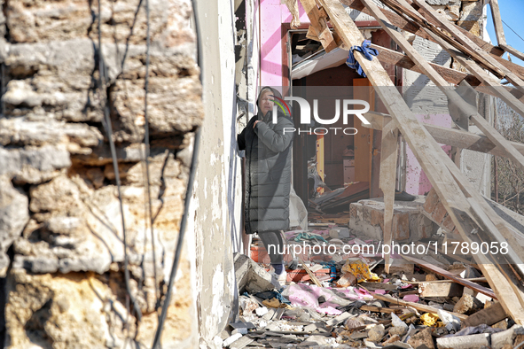 A woman stands outside a house damaged by a large-scale Russian missile strike in the Odesa region, Ukraine, on November 17, 2024. In the re...