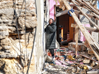 A woman stands outside a house damaged by a large-scale Russian missile strike in the Odesa region, Ukraine, on November 17, 2024. In the re...