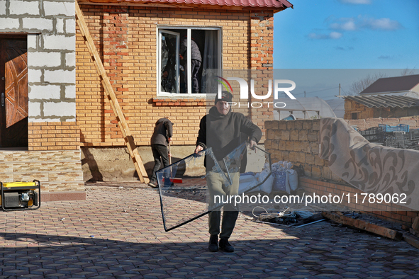 In the Odesa region, Ukraine, on November 17, 2024, a man carries a broken window pane after a large-scale Russian missile strike. In the re...