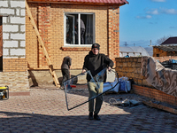 In the Odesa region, Ukraine, on November 17, 2024, a man carries a broken window pane after a large-scale Russian missile strike. In the re...