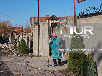 An elderly woman stands at the gate of a house damaged by a large-scale Russian missile strike in the Odesa region, Ukraine, on November 17,...