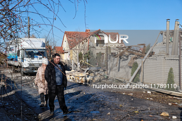 A man and woman walk along a street affected by a large-scale Russian missile strike in the Odesa region, Ukraine, on November 17, 2024. In...