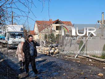 A man and woman walk along a street affected by a large-scale Russian missile strike in the Odesa region, Ukraine, on November 17, 2024. In...