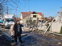 A man and woman walk along a street affected by a large-scale Russian missile strike in the Odesa region, Ukraine, on November 17, 2024. In...