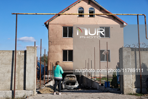 A woman faces a house damaged by a large-scale Russian missile strike in the Odesa region, Ukraine, on November 17, 2024. In the recent mass...