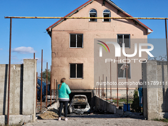 A woman faces a house damaged by a large-scale Russian missile strike in the Odesa region, Ukraine, on November 17, 2024. In the recent mass...