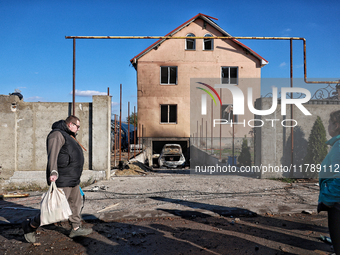 A man and a woman stand outside a house damaged by a large-scale Russian missile strike in the Odesa region, Ukraine, on November 17, 2024....