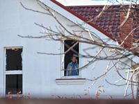 In the Odesa region, Ukraine, on November 17, 2024, a woman talks on the phone while standing in a window smashed by a large-scale Russian m...