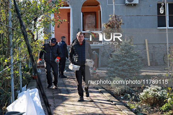 Men remove debris from the premises of a house damaged by a large-scale Russian missile strike in Odesa region, Ukraine, on November 17, 202...