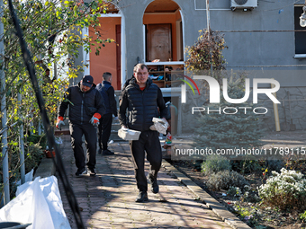 Men remove debris from the premises of a house damaged by a large-scale Russian missile strike in Odesa region, Ukraine, on November 17, 202...