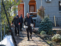 Men remove debris from the premises of a house damaged by a large-scale Russian missile strike in Odesa region, Ukraine, on November 17, 202...