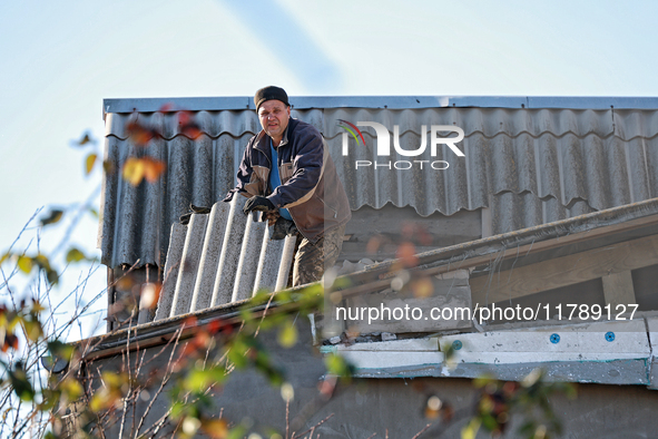 In the Odesa region, Ukraine, on November 17, 2024, a man removes broken shingle tiles from the roof of a house damaged by a large-scale Rus...