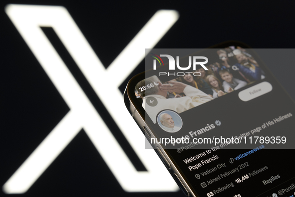 An editorial image shows an iPhone screen displaying Pope Francis' personal account on the X social network platform. The X logo appears sub...