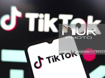 The logo of the social network TikTok appears on the screen of a smartphone and in the background on the computer in Reno, United States, on...