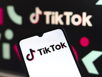 The logo of the social network TikTok appears on the screen of a smartphone and in the background on the computer in Reno, United States, on...