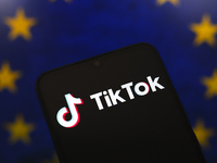 The logo of the social network TikTok appears on the screen of a smartphone, and in the background, the flag of the European Union (EU) is d...