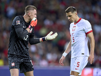 Marcin Bulka of Poland talks with Jan Bednarek of Poland during the UEFA Nations League 2024/25 League A Group A1 match between Portugal and...