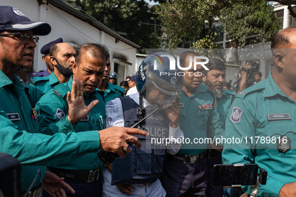 Police personnel escort a detainee to the International Crimes Tribunal (ICT) court on charges of massacres, killings, and crimes against hu...