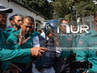 Police personnel escort a detainee to the International Crimes Tribunal (ICT) court on charges of massacres, killings, and crimes against hu...