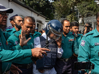 Police personnel escort a detainee to the International Crimes Tribunal (ICT) court on charges of massacres, killings, and crimes against hu...