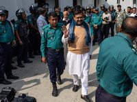 Police personnel escort detainee Shajahan Khan, a former Member of Parliament of Bangladesh's ousted government led by the Bangladesh Awami...