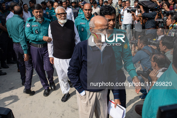 Police personnel escort detainee Kamal Ahmed Majumdar, a former minister of Bangladesh's ousted government led by the Bangladesh Awami Leagu...