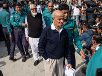 Police personnel escort detainee Kamal Ahmed Majumdar, a former minister of Bangladesh's ousted government led by the Bangladesh Awami Leagu...