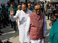 Police personnel escort detainees Hasanul Haque Inu and Rashed Khan Menon, both former members of parliament and former ministers of Banglad...