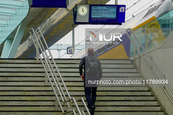 A traveler walks up the stairs to Platform 9 at Arnhem Centraal Station in Arnhem, Netherlands, on July 27, 2023. The signage above displays...