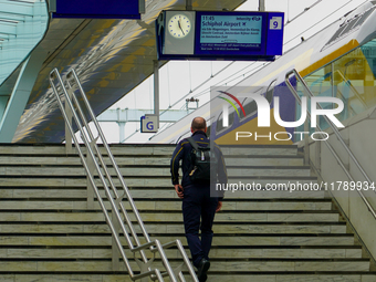 A traveler walks up the stairs to Platform 9 at Arnhem Centraal Station in Arnhem, Netherlands, on July 27, 2023. The signage above displays...