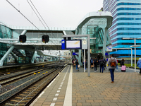 Travelers and commuters walk along Platform 4 at Arnhem Centraal Station in the Netherlands on July 27, 2023. The station's modern architect...