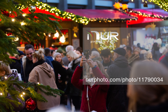 Visitors check the stalls selling Christmas decorations at Cologne Christmas in front of Dam Cathedral in Cologne, Germany, on November 18,...