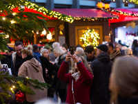 Visitors check the stalls selling Christmas decorations at Cologne Christmas in front of Dam Cathedral in Cologne, Germany, on November 18,...