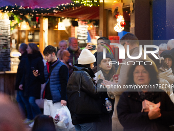 Visitors check the stalls selling Christmas decorations at Cologne Christmas in front of Dam Cathedral in Cologne, Germany, on November 18,...