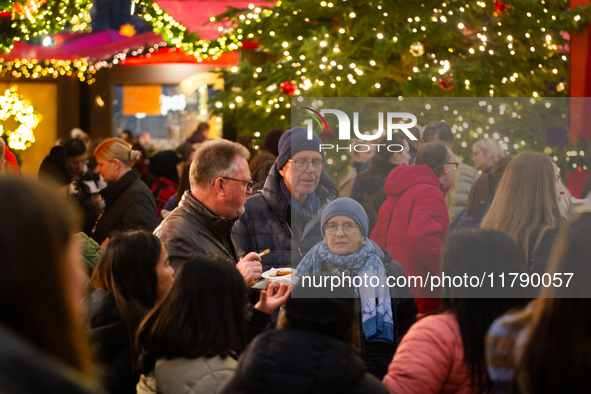 Visitors check the stalls selling Christmas decorations at Cologne Christmas in front of Dam Cathedral in Cologne, Germany, on November 18,...