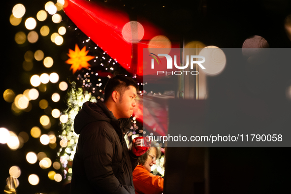 Visitors check the stalls selling Christmas decorations at Cologne Christmas in front of Dam Cathedral in Cologne, Germany, on November 18,...