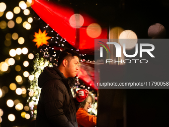 Visitors check the stalls selling Christmas decorations at Cologne Christmas in front of Dam Cathedral in Cologne, Germany, on November 18,...