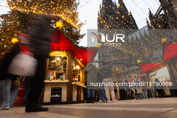 Visitors check the stalls selling Christmas decorations at Cologne Christmas in front of Dam Cathedral in Cologne, Germany, on November 18,...