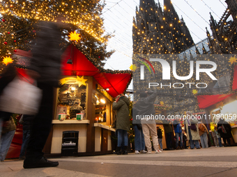 Visitors check the stalls selling Christmas decorations at Cologne Christmas in front of Dam Cathedral in Cologne, Germany, on November 18,...