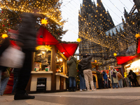 Visitors check the stalls selling Christmas decorations at Cologne Christmas in front of Dam Cathedral in Cologne, Germany, on November 18,...