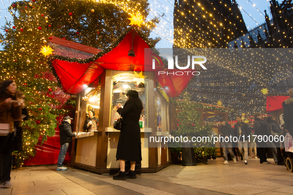 Visitors check the stalls selling Christmas decorations at Cologne Christmas in front of Dam Cathedral in Cologne, Germany, on November 18,...