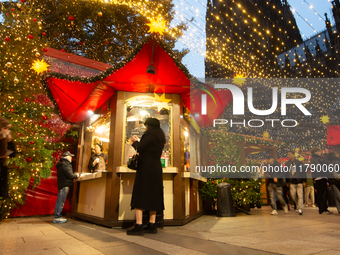 Visitors check the stalls selling Christmas decorations at Cologne Christmas in front of Dam Cathedral in Cologne, Germany, on November 18,...