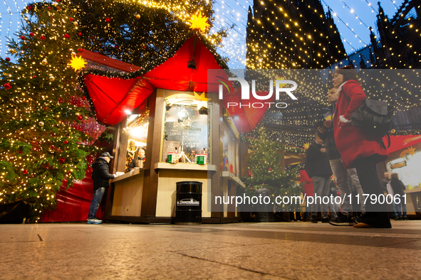 Visitors check the stalls selling Christmas decorations at Cologne Christmas in front of Dam Cathedral in Cologne, Germany, on November 18,...