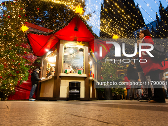 Visitors check the stalls selling Christmas decorations at Cologne Christmas in front of Dam Cathedral in Cologne, Germany, on November 18,...