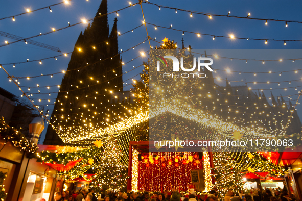 Visitors check the stalls selling Christmas decorations at Cologne Christmas in front of Dam Cathedral in Cologne, Germany, on November 18,...