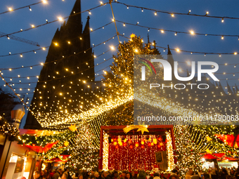 Visitors check the stalls selling Christmas decorations at Cologne Christmas in front of Dam Cathedral in Cologne, Germany, on November 18,...