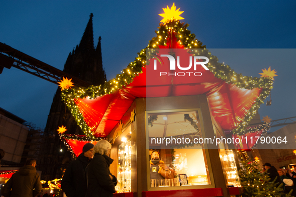 Visitors check the stalls selling Christmas decorations at Cologne Christmas in front of Dam Cathedral in Cologne, Germany, on November 18,...