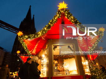 Visitors check the stalls selling Christmas decorations at Cologne Christmas in front of Dam Cathedral in Cologne, Germany, on November 18,...