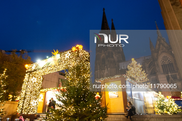 Visitors check the stalls selling Christmas decorations at Cologne Christmas in front of Dam Cathedral in Cologne, Germany, on November 18,...